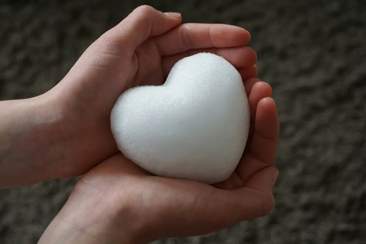Hands holding a white heart