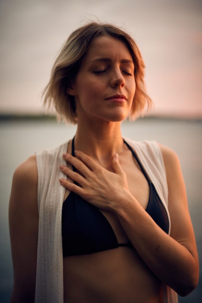 A woman with her eyes closed and a hand resting on her chest