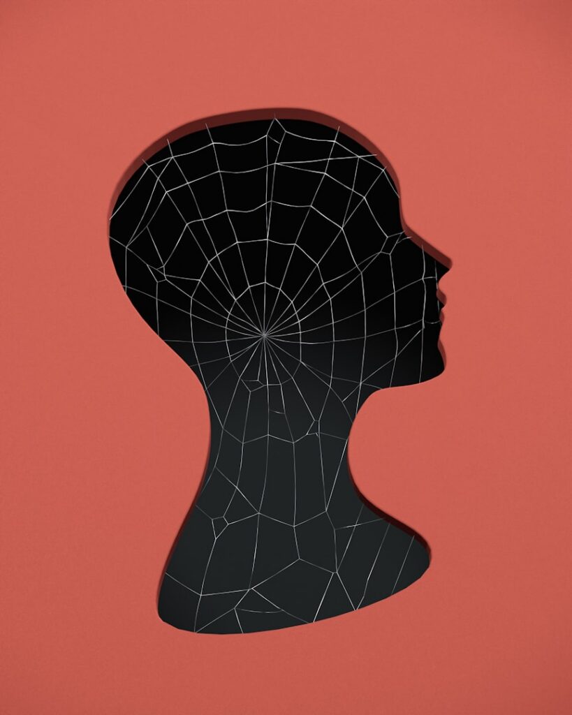 A dark head silhouette with a mesh pattern on a red background