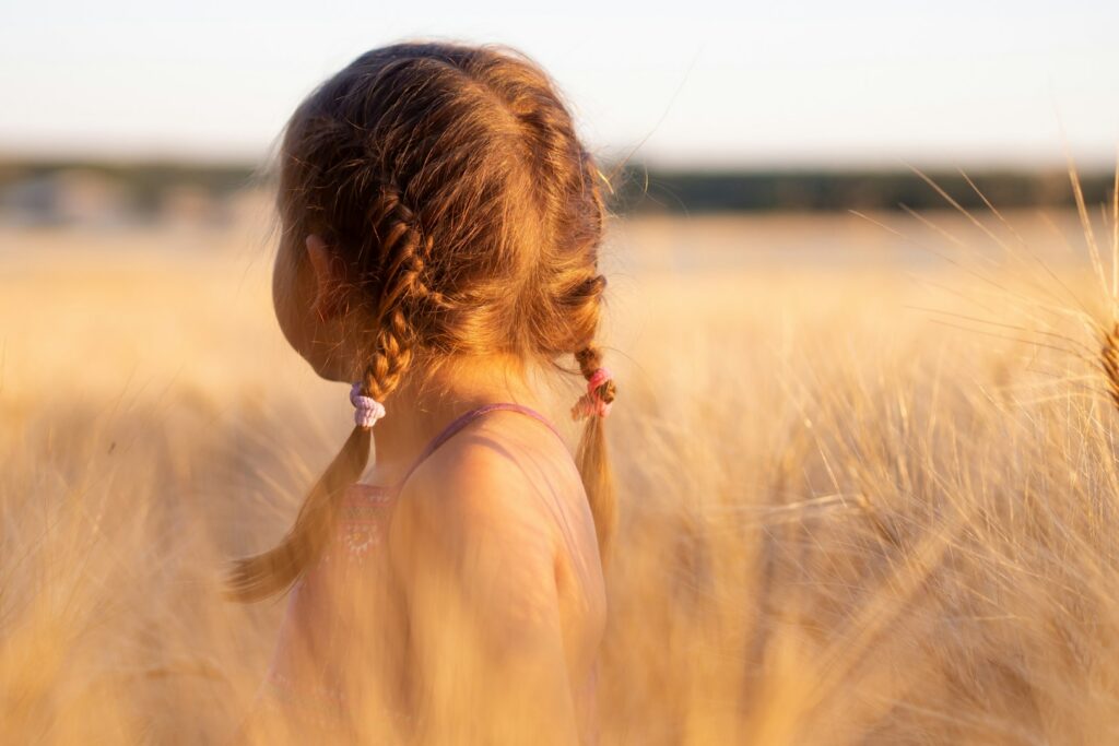 A young girl with braids in a golden field